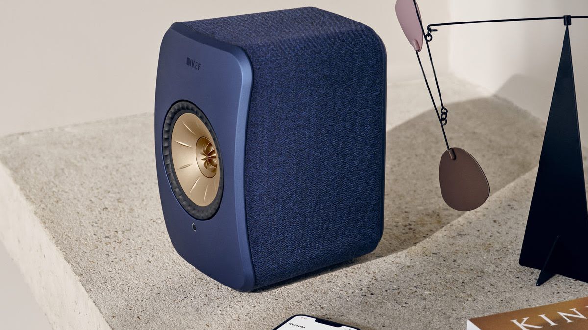 KEF LSX II in blue on a desk, beside a smartphone