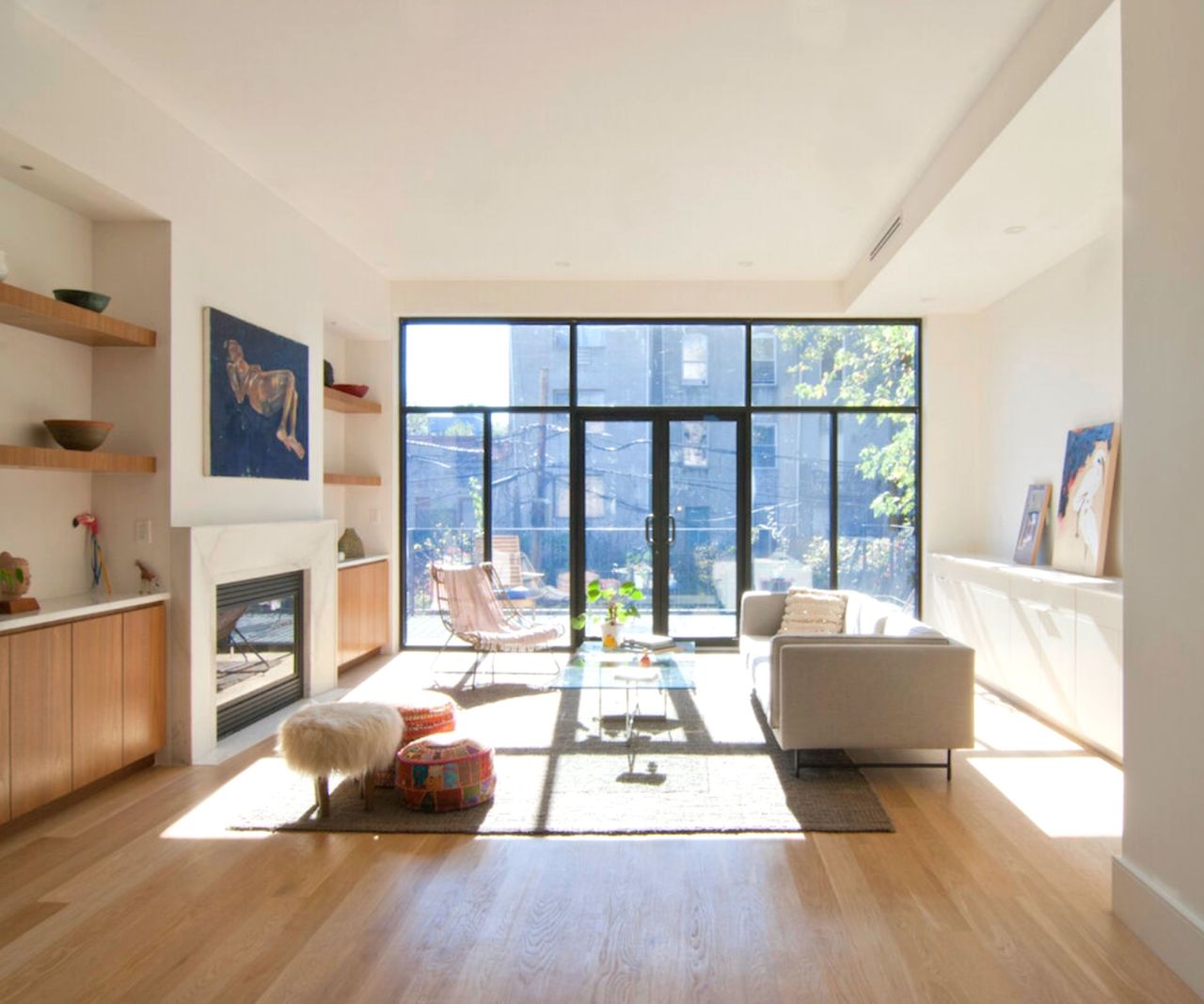 neutral living room with floor to ceiling glass and balcony