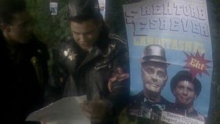 Still from the British sci-fi sitcom called Red Dwarf. Here we see the Cat and Lister in the episode 'Backwards' looking at a backwards poster.