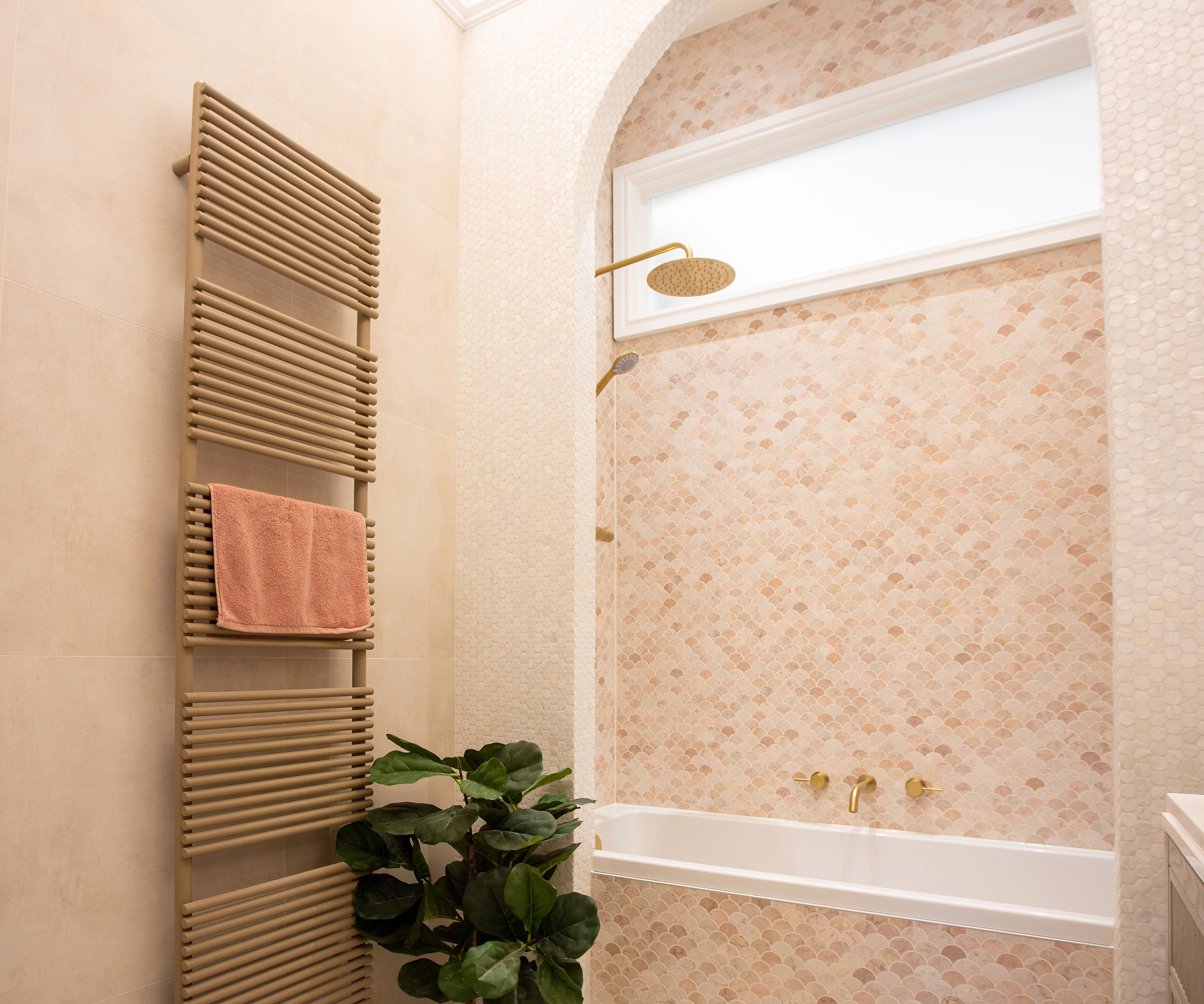pink bathroom with large heated towel rail and pink mosaic tiles