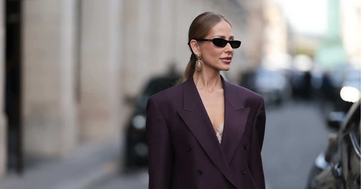 Alcohol-free perfumes Ginta is seen wearing a dark purple, double-breasted suit from Dries with strong shoulder pads at the Paris Fashion Week on October 02, 2025 in Paris, France. 
