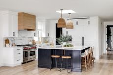 white kitchen with blue cabinets and natural materials by Lindye Galloway