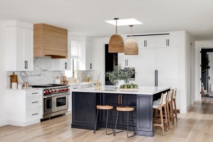 white kitchen with blue cabinets and natural materials by Lindye Galloway