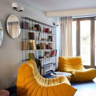 living room with yellow couch and book shelves
