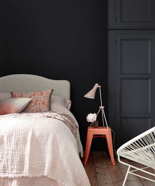 bedroom with black walls, pale pink bedding