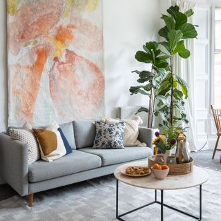 White living room with a circle shaped marble coffee table, modern décor and green plants
