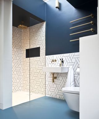 An example of small bathroom flooring ideas showing blue shower room flooring and white wall tiles with black grouting