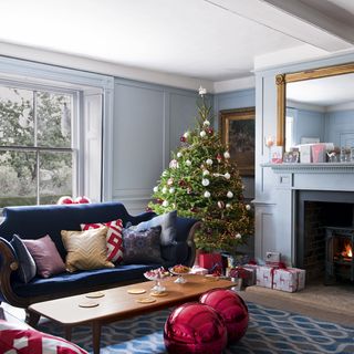 living area with christmas tree and blue sofa and fire place