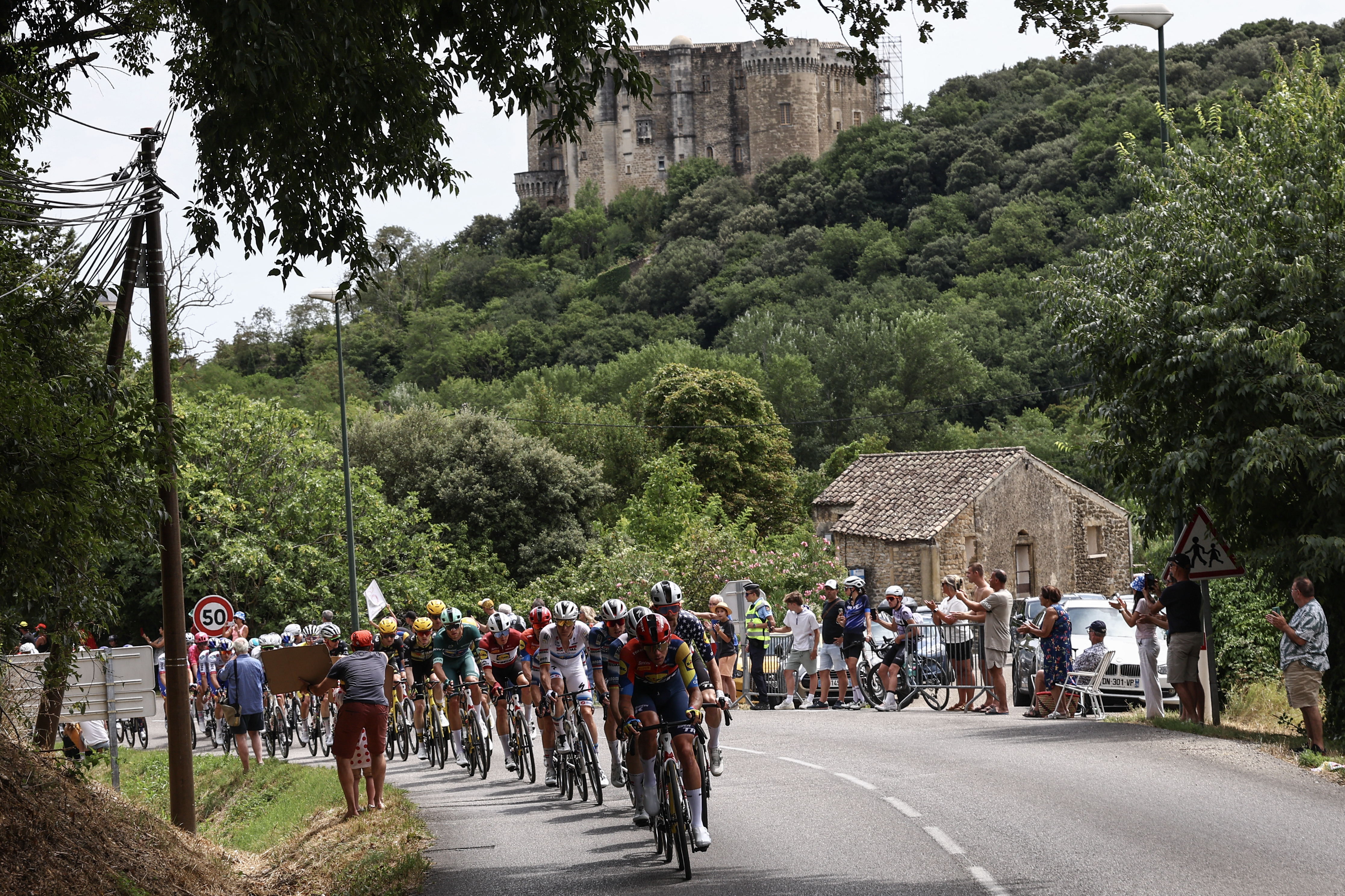 The pack of riders (peloton) cycles past the Chateau de Suze-la-Rousse during the 17th stage of the 112th edition of the Tour de France cycling race, 160.4 km between Bollene and Valence, southern France, on July 23, 2025. (Photo by Anne-Christine POUJOULAT / AFP) (Photo by ANNE-CHRISTINE POUJOULAT/AFP via Getty Images)