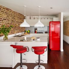 white kitchen with red bar stools