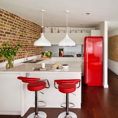 white kitchen with red bar stools