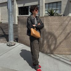 alyssa wears jeans leather jacket red shoes and tan handbag