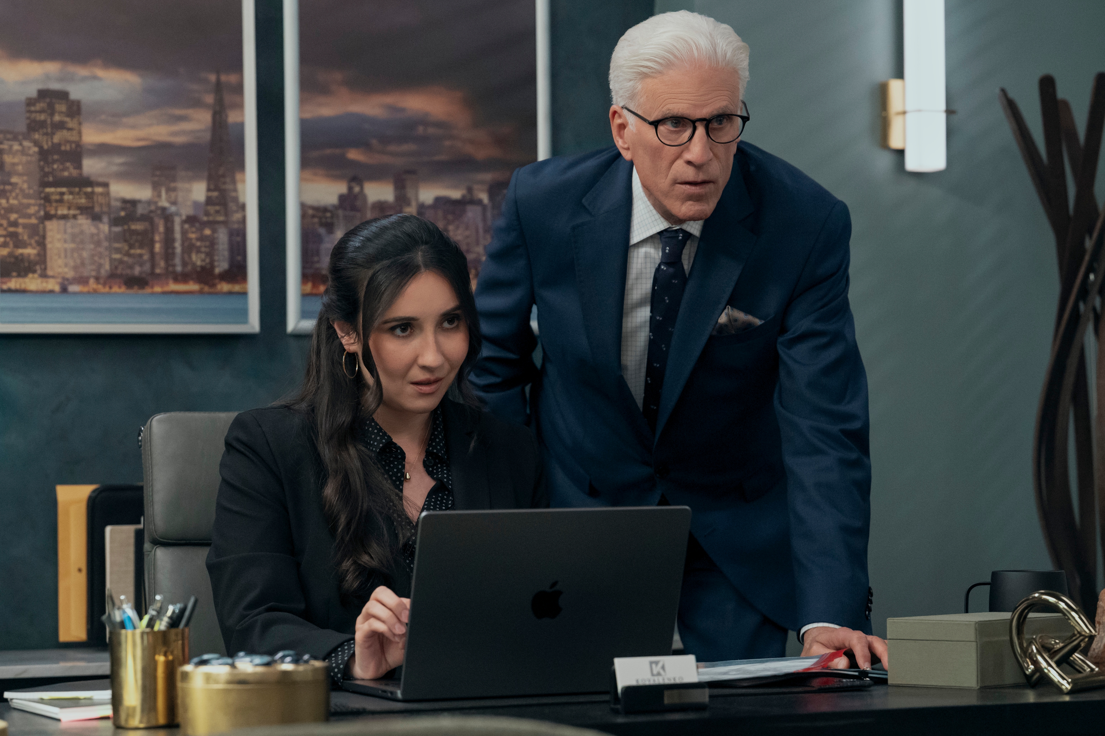 A Man on the Inside season 2 still with Lilah Richcreek Estrada as Julie and Ted Danson as Charles looking at a laptop in julie&#039;s office