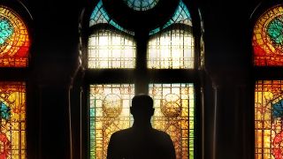 David Sconce in front of stained glass windows