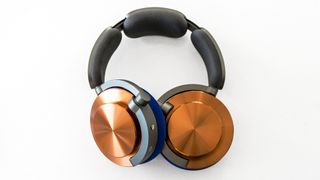 Dyson OnTrac headphones with gold outer caps and purple ear cups.