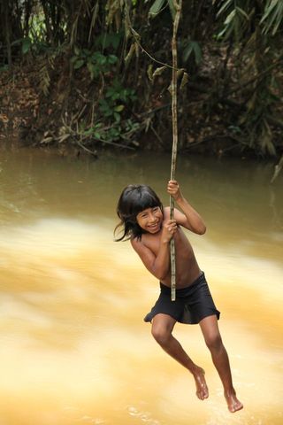 An Awa child plays in a stream.