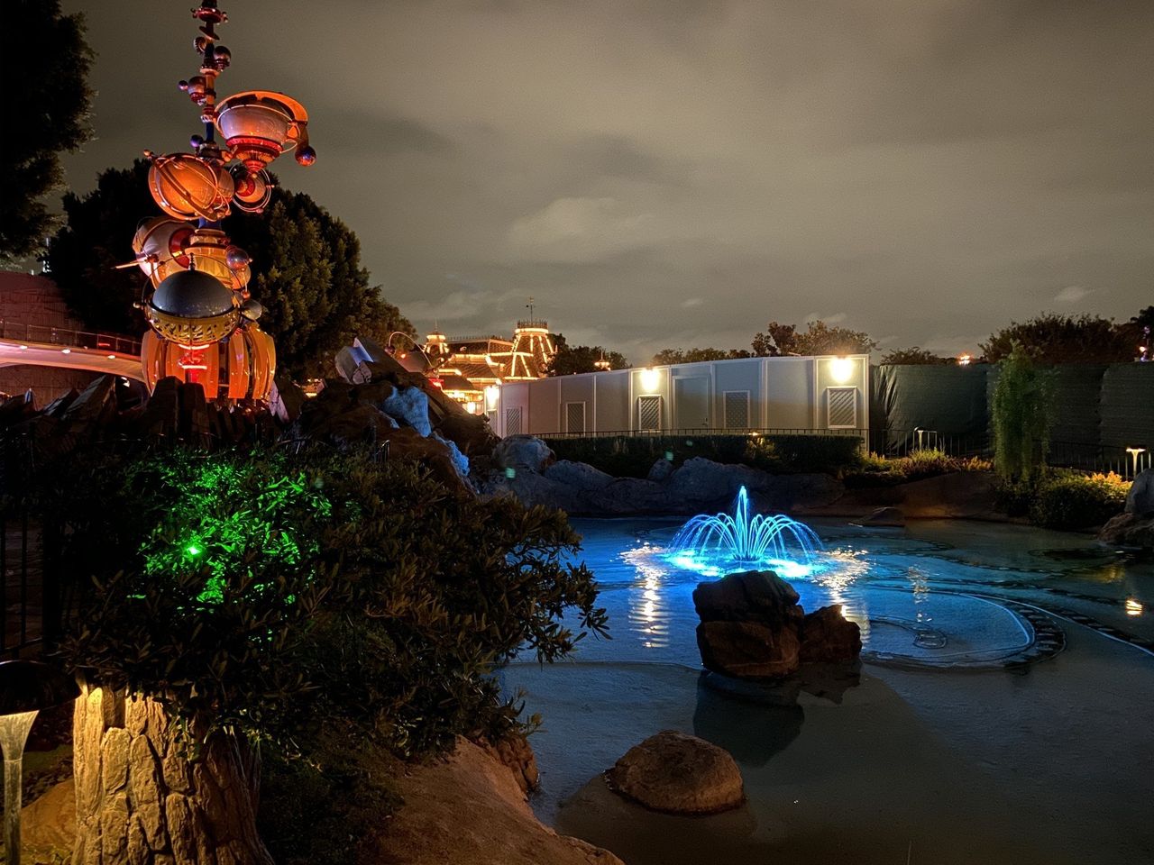 Pixie's Hollow fountain in front of Tomorrowland in Night mode