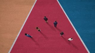 Several people standing on coloured tarmac tracks