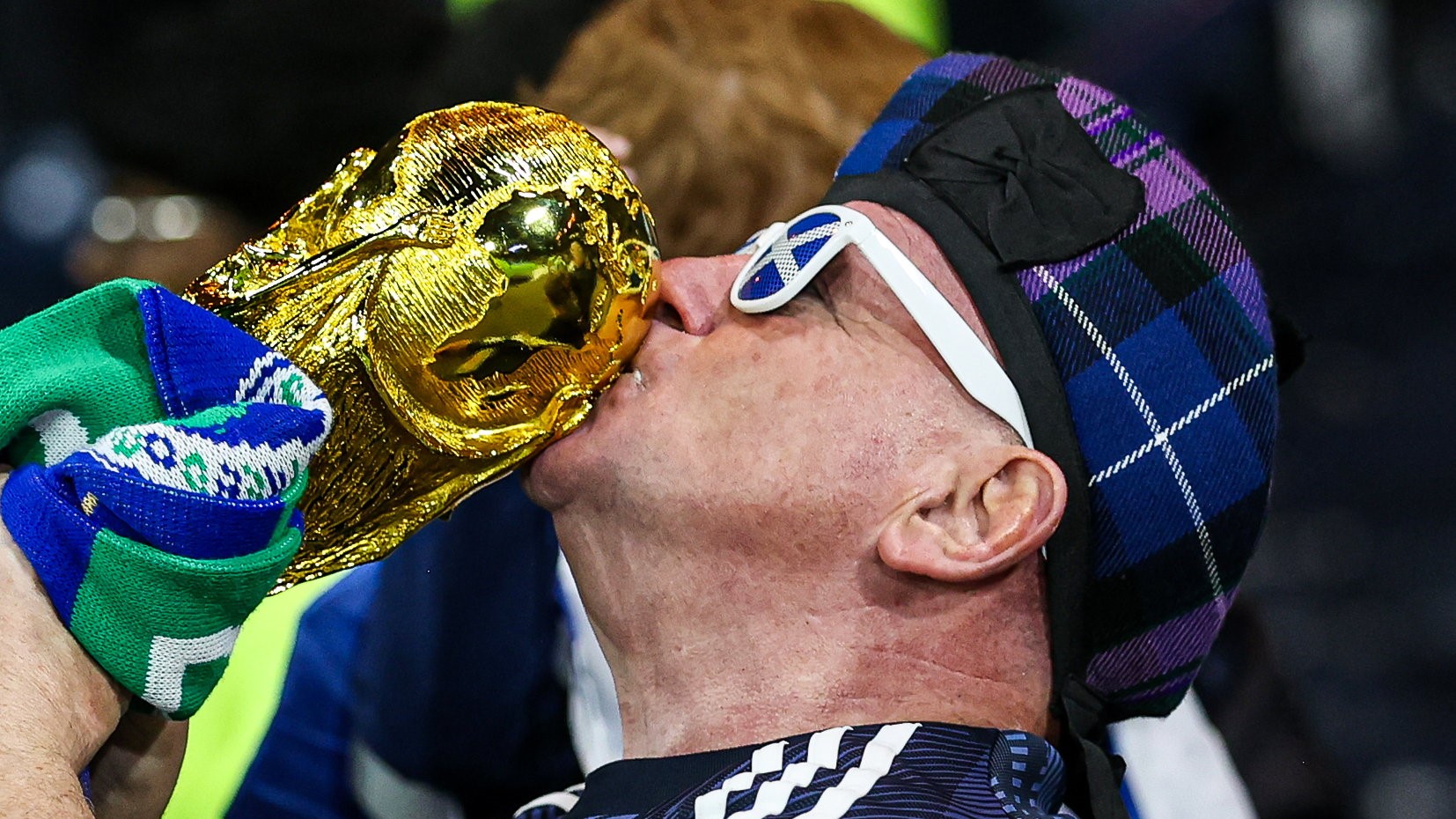 A Scotland fan kisses a replica of the Jules Rimet trophy.