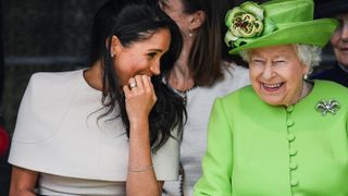 Queen Elizabeth II sitts and laughs with Meghan, Duchess of Sussex during a ceremony to open the new Mersey Gateway Bridge on June 14, 2018