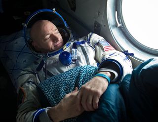 Expedition 26 commander Scott Kelly, wearing a turquoise wristband in honor of sister-in-law Gabrielle Giffords, looks out the window of a Russian Search and Rescue helicopter before the two hour helicopter ride to Kustanay, Kazakhstan shortly after he an