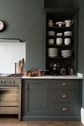 a small kitchen idea in dark charcoal grey with gold accent and matching colored wall with open cabinetry and stainless steel range cooker
