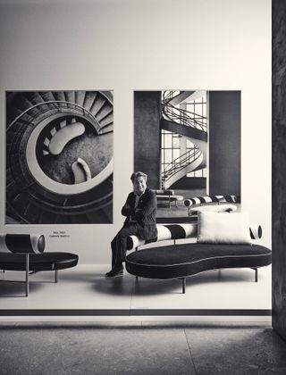 Antonio Citterio on sofa at Flexform photography show in Milan