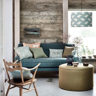 living area with grey sofa and chair and wooden panel