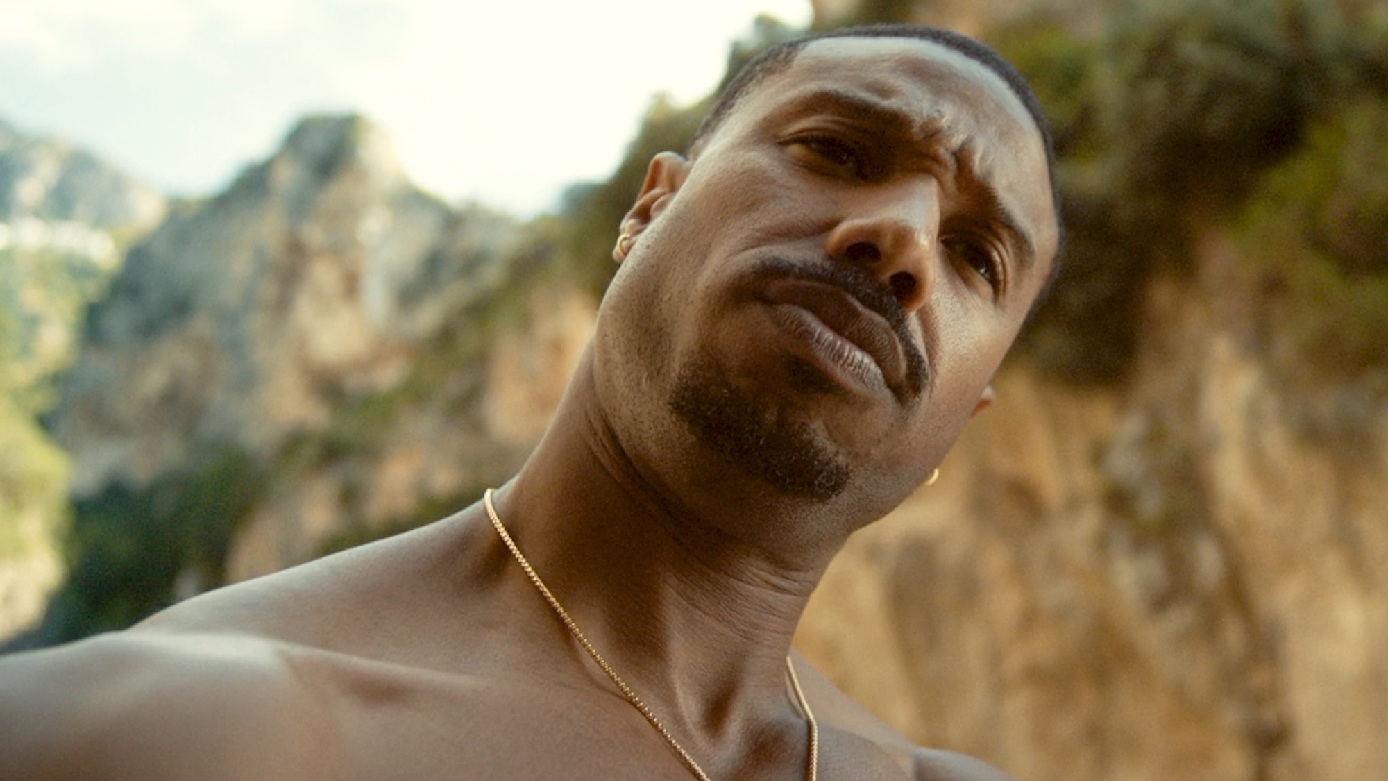 Michael B. Jordan looking dubious outside in The Thomas Crown Affair