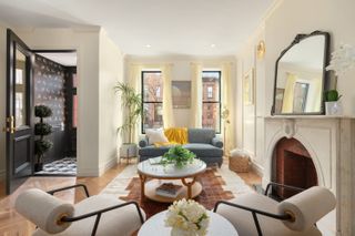 A light living room with blue and yellow accents and a dark hallway design to the side