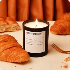 A Buttery Croissant candle from Not on the High Street surrounded by croissants