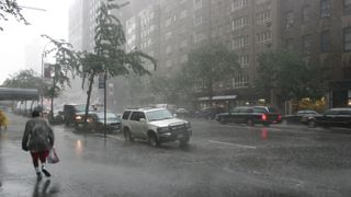 A pedestrial runs down a sidewalk in New York City during a bout of torrential rain.