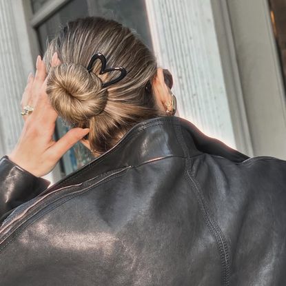 Deborah Pagani wearing her hair in a bun with a black heart shaped french hair pin 