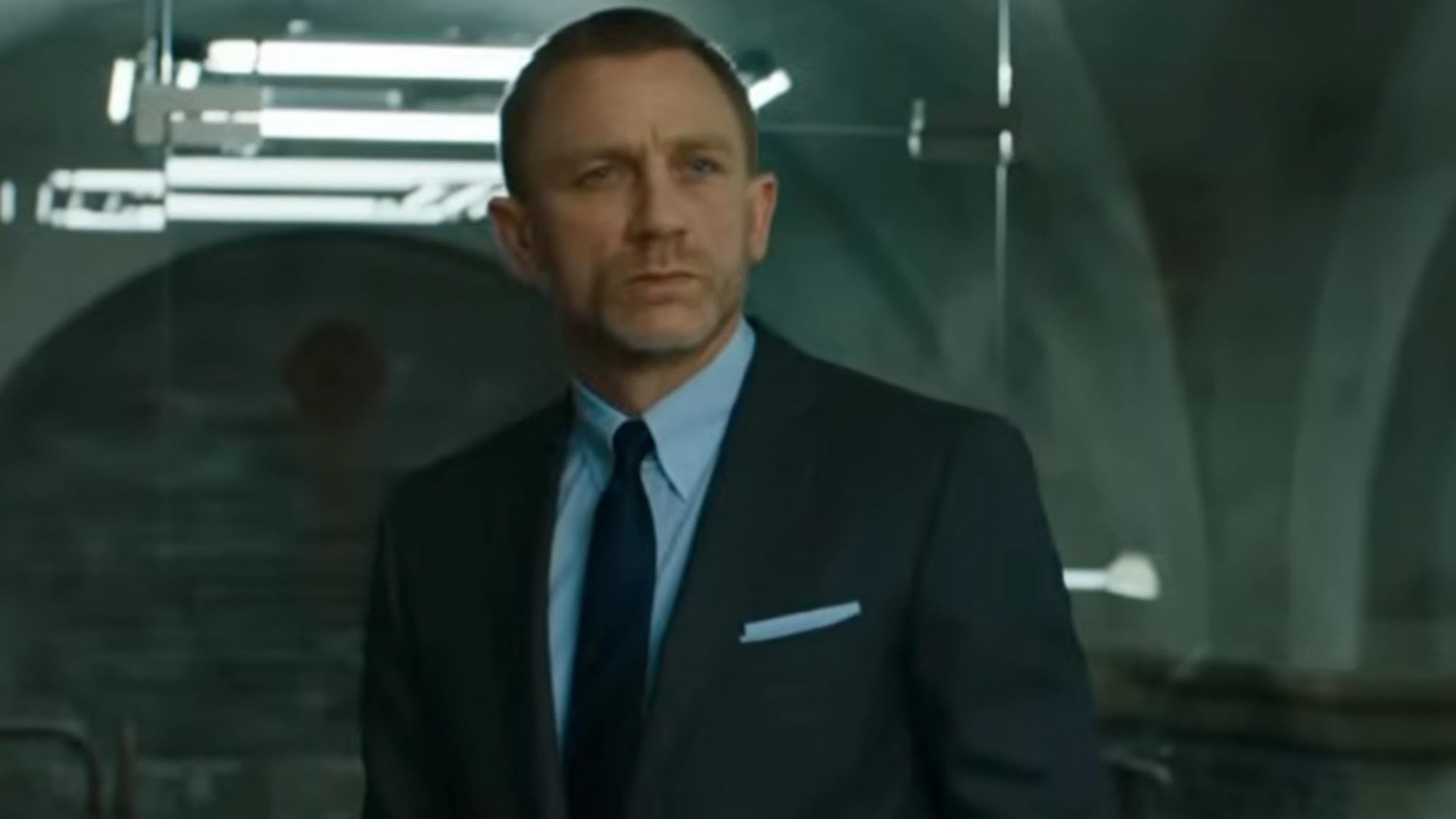 Daniel Craig as James Bond in a suit, looking past the camera.