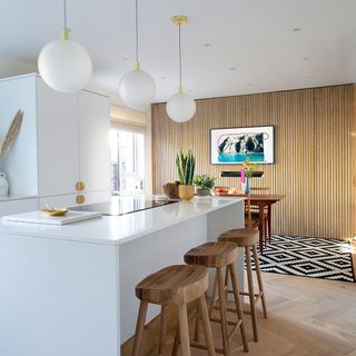 white kitchen with island and wood veneer feature wall