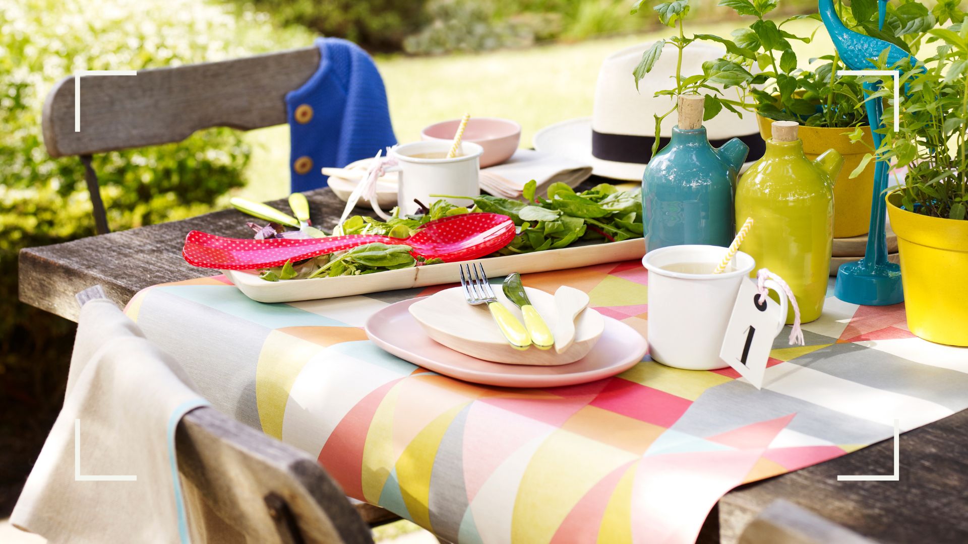 Outdoor dining table with a geometric table runner with food and plates ready to serve