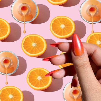 a pink background with oranges and a hand wearing orange nail polish