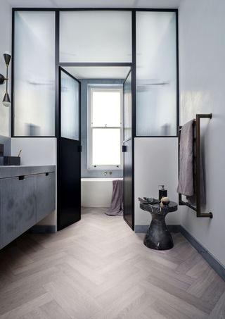 grey bathroom with vinyl wooden effect floor, crittal style doors and windows through to the bath