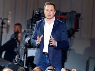 Elon Musk speaks in front of employees during the delivery of the first Tesla vehicle Model 3 on July 28, 2017.