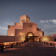 A lit building with a blue sky at dusk.