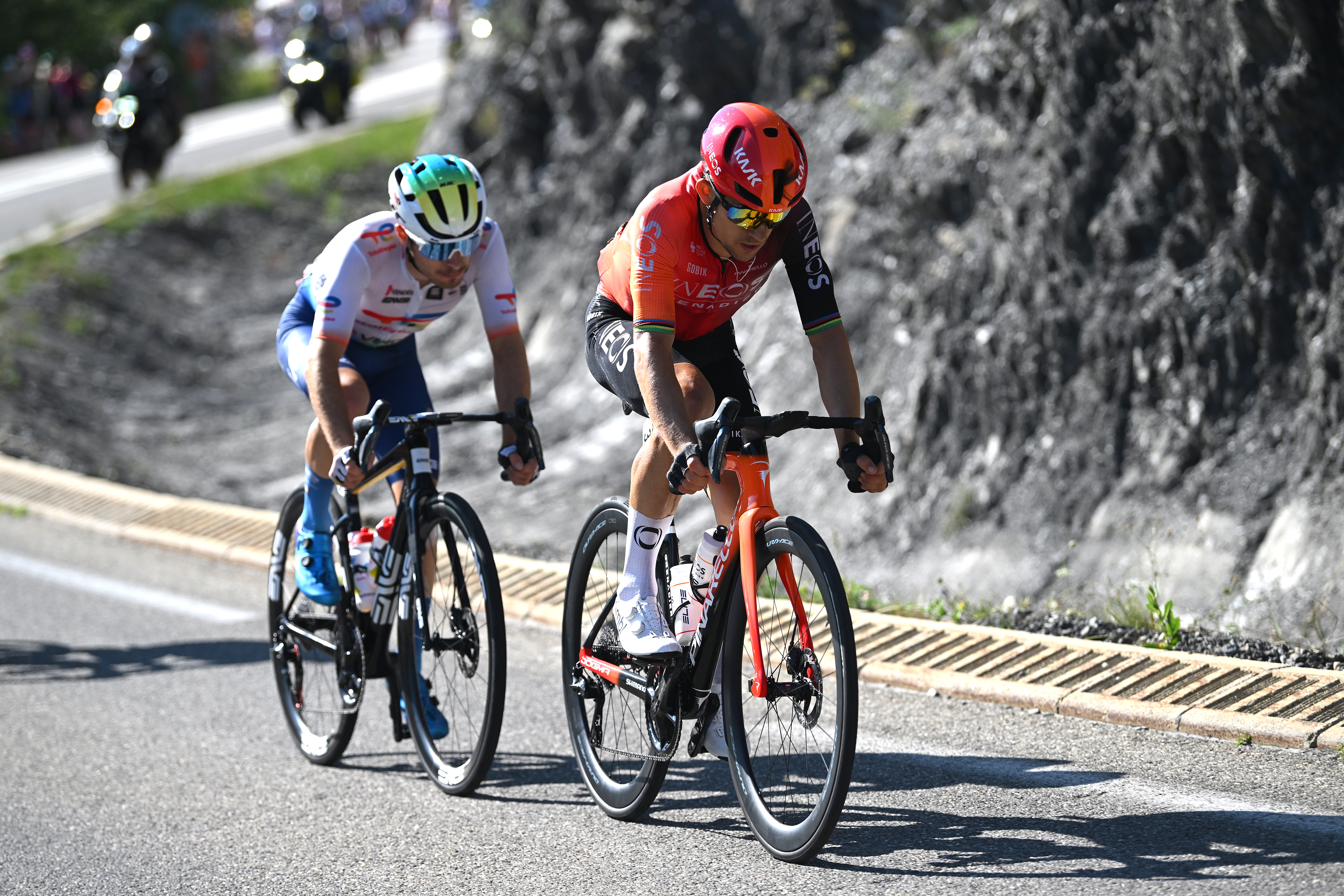 An Ineos Grenadiers rider and a TotalEnergies rider at the 2024 Tour de France
