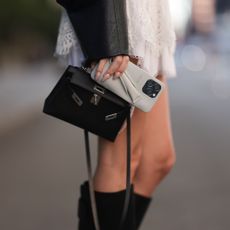 woman holding a rhode phone case, black hermes handbag with muted nails - best nail strengtheners