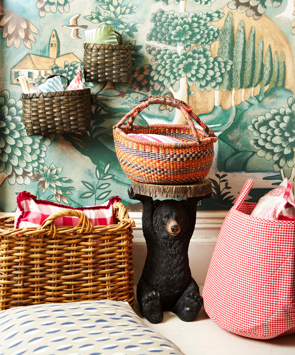 A green and blue patterned wallpaper with numerous colorful and wicker baskets acting as storage in small bedroom ideas for kids.