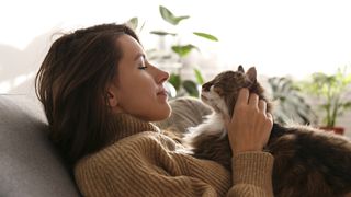 Lady giving cat a cuddle