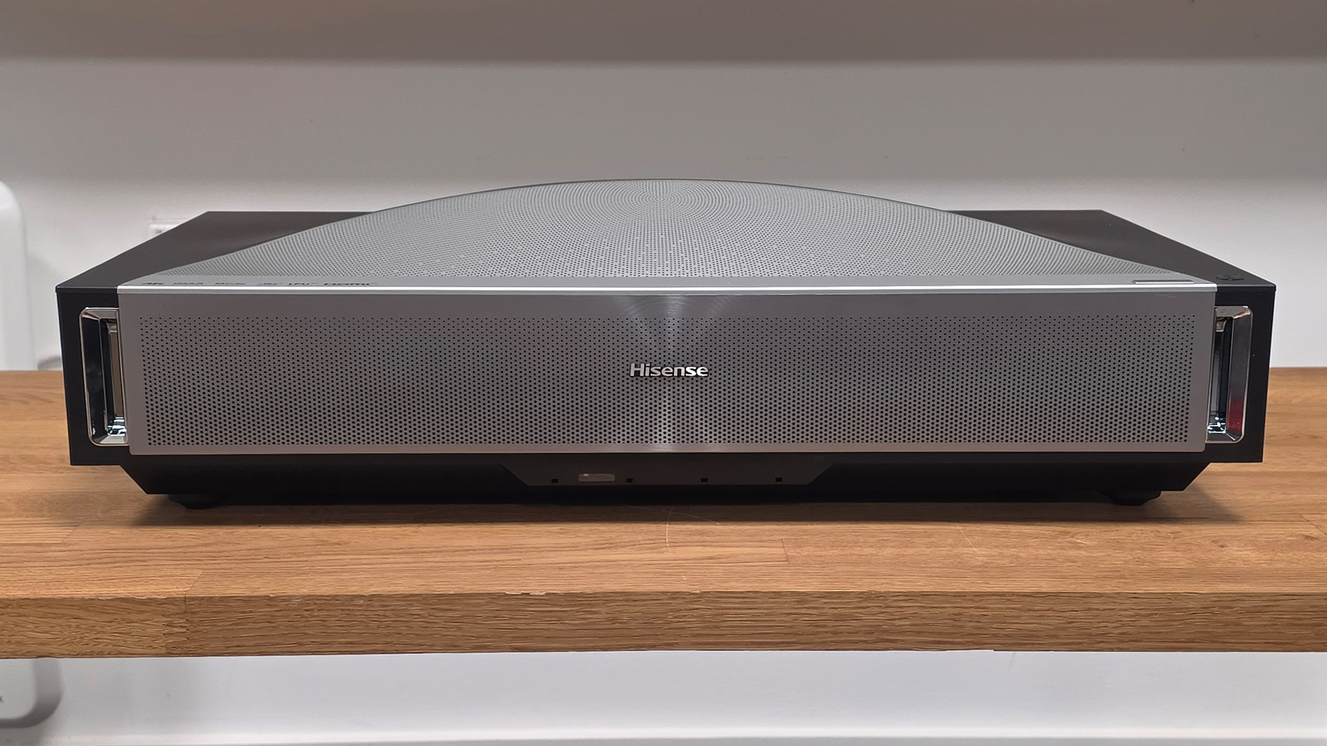 Hisense PX4 Pro UST projector on wooden AV rack