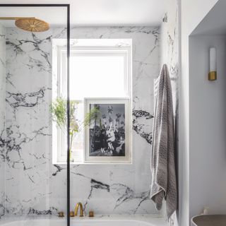 marble bathroom with brass taps and towel hung on radiator