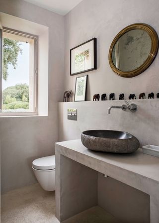 powder room with plaster colored walls stone sink