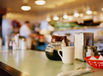A diner counter with a coffee pot and cup
