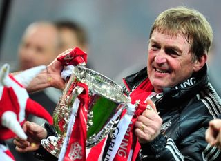 Kenny Dalglish celebrates with the League Cup trophy after Liverpool's win on penalties against Cardiff City in the 2012 final.