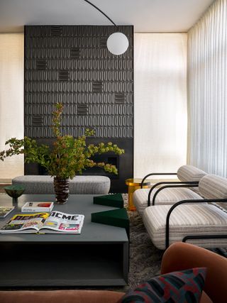 A living room with cream walls, and a black-painted fireplace